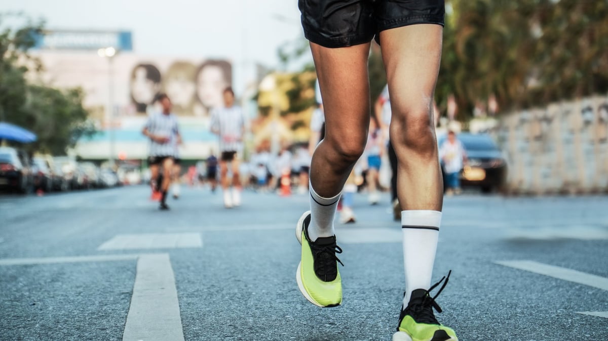 Pies de un corredor en pleno movimiento durante un maratón urbano